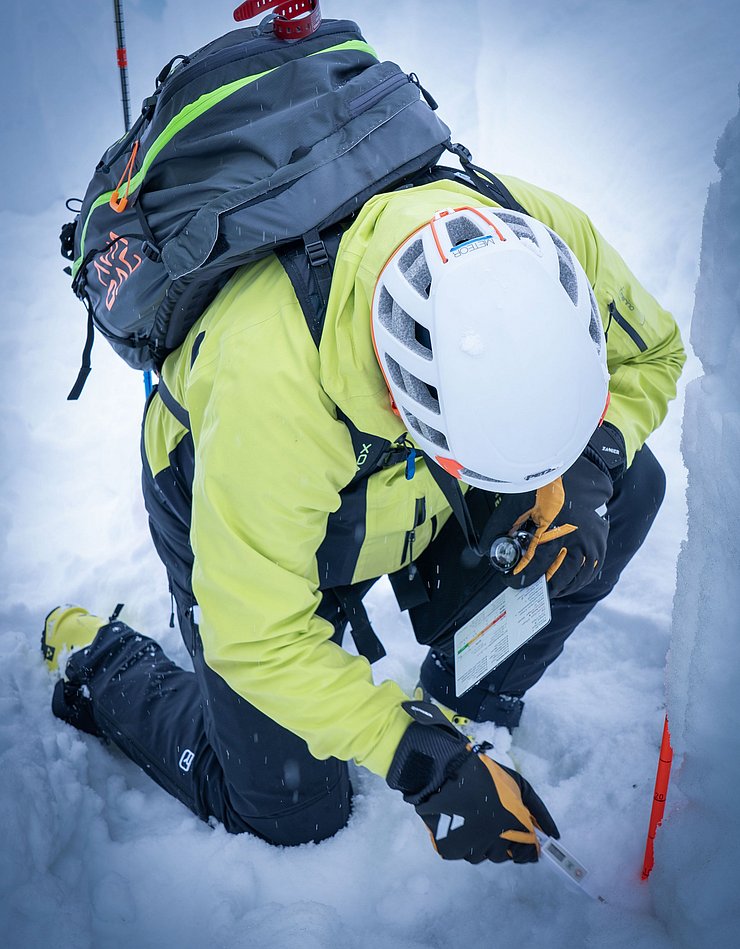 Mann untersucht Schnee