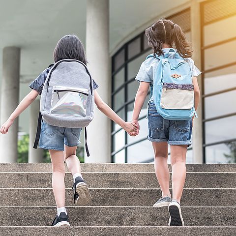 Schule, zwei Mädchen auf dem Weg zur Schule, Schultaschen