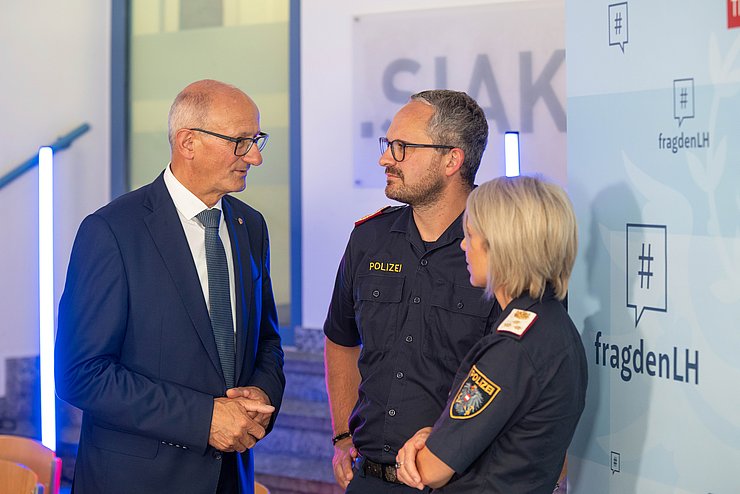 Drei Menschen befinden sich in einem Gespräch.