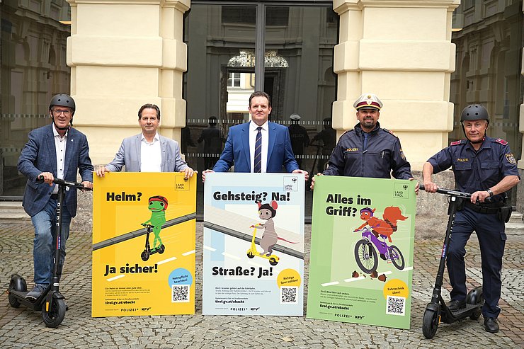 Männer mit Plakaten und E-Scootern