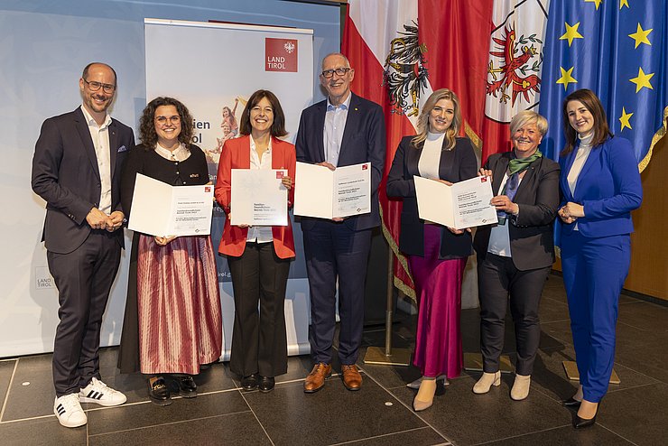 © Land Tirol/Die Fotografen sieben Personen mit Urkunden