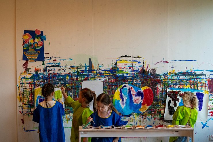 Kinder gestalten eine bunte Wand
