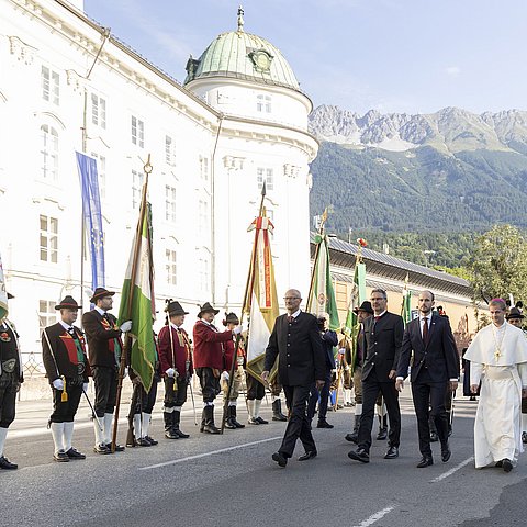 Die Personen schreiten der Straße entlang - am Rand stehen die Formationen