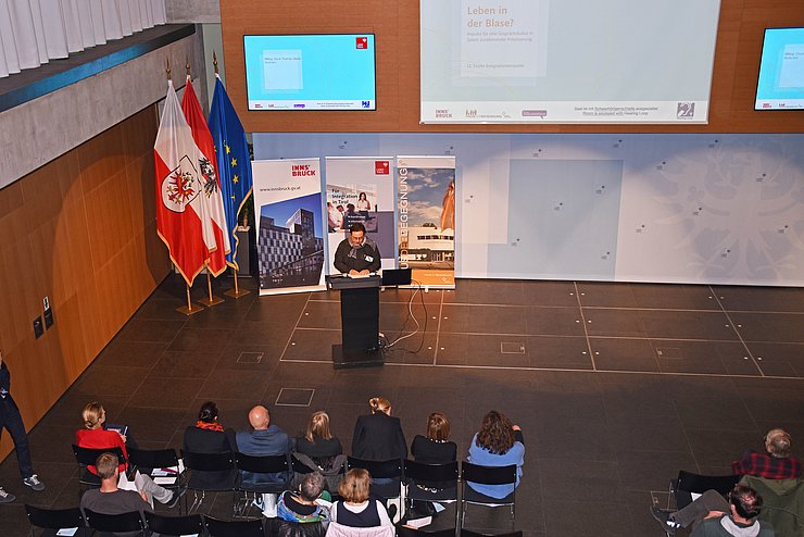 Saal mit TeilnehmerInnen und Leinwand von oben