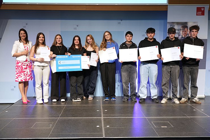 © Land Tirol/Trenker Jugendliche mit Urkunden und eine Frau auf der Bühne