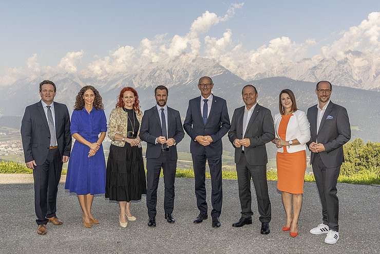 Gruppenfoto der Regierungsmitglieder. Im Hintergrund ist eine Gebirgskette zu sehen.