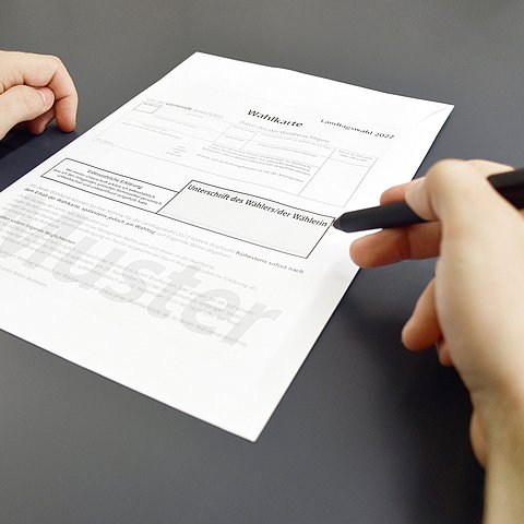 Foto von Wahlkarte und Händen mit Stift