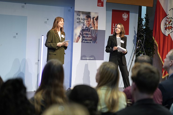 Zwei Frauen sprechen vor Publikum