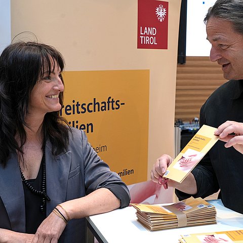 Mann zwei Frauen Broschüre zeigend