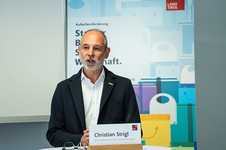 © Land Tirol/Fitsch Mann mit Bart an einem Rede-Pult
