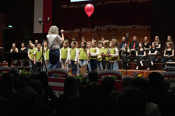 Kinder singen, Frau dirigiert