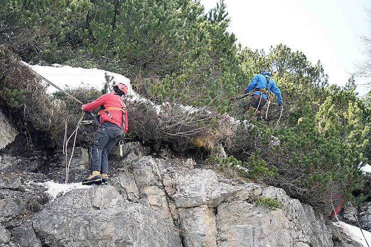 Männer mit Kletterausrüstung in Felswand