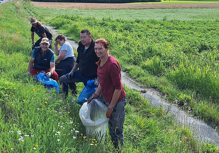 Gruppe von Menschen an Straßenböschung