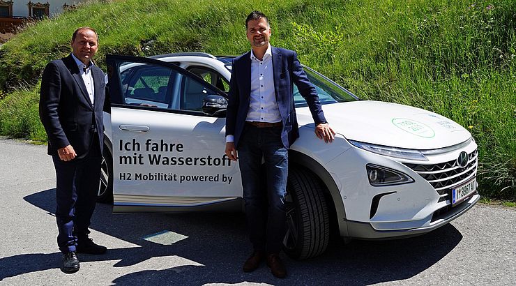 Landeshauptmann-Stellvertreter Josed Geisler und Wasser-Tirol-Geschäftsführer Rupert Ebenbichler stehen vor dem wasserstoffbetriebenen Fahrzeug. 