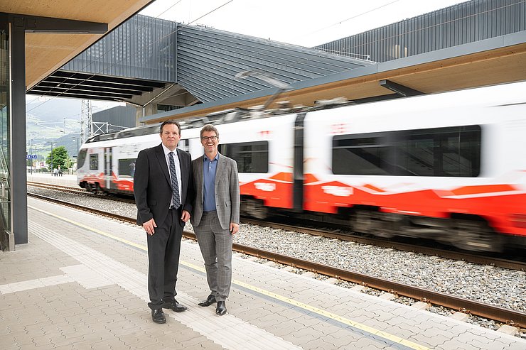 © Birgit Pichler zwei Personen am Bahnsteig, im Hintergrund ein fahrender Zug