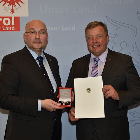 Gesundheitslandesrat Tilg gratuliert Landessanitätsdirektor Katzgraber (li.) zum Großen Ehrenzeichen für Verdienste um die Republik Österreich.