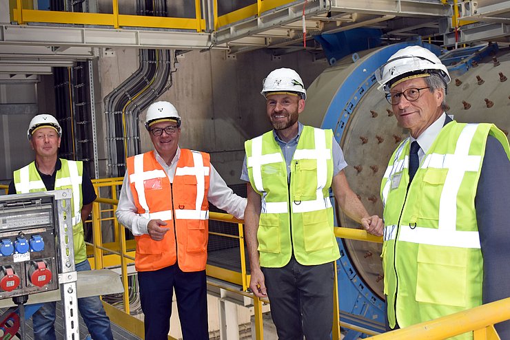 Ernst Herzinger (Leitung Anlagentechnik), LH Günther Platter, Thomas Ostheimer (technische Leitung) und . Geschäftsführer von Schretter & Cie Reinhard Schretter - im Hintergrund die Kugelmühle als Teil des Zementmahlsystems. 