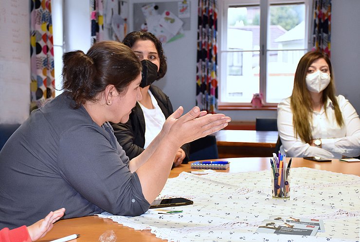 Die Teilnehmerinnen am Tisch, eine Teilnehmerin gestikuliert mit den Händen