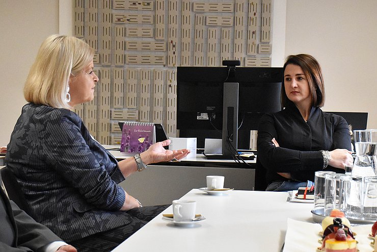 Klaudia Tanner und Astrid Mair unterhalten sich am Tisch sitzend.