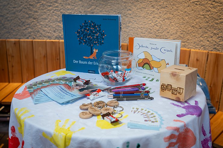 © Land Tirol/Neuner Stehtisch mit Büchern und Süßigkeiten.