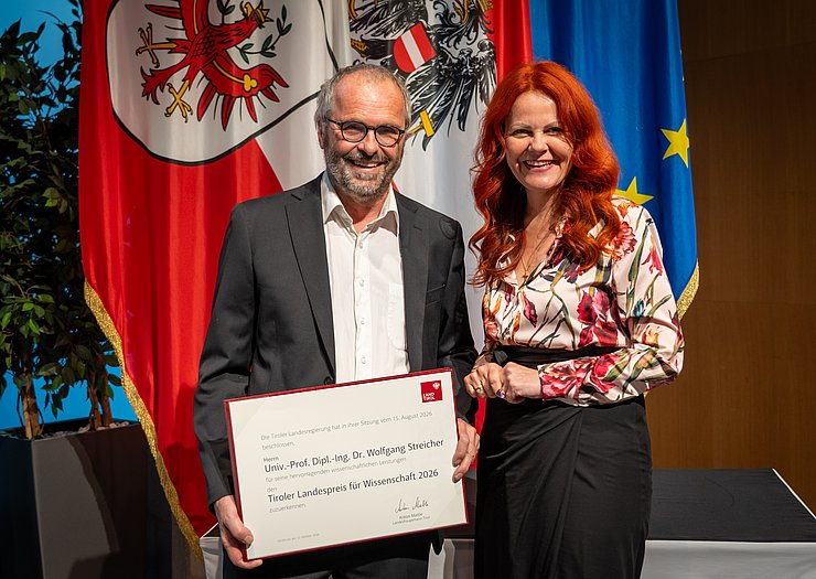 © Land Tirol/Neuner Streicher und Hagele vor Fahnen.