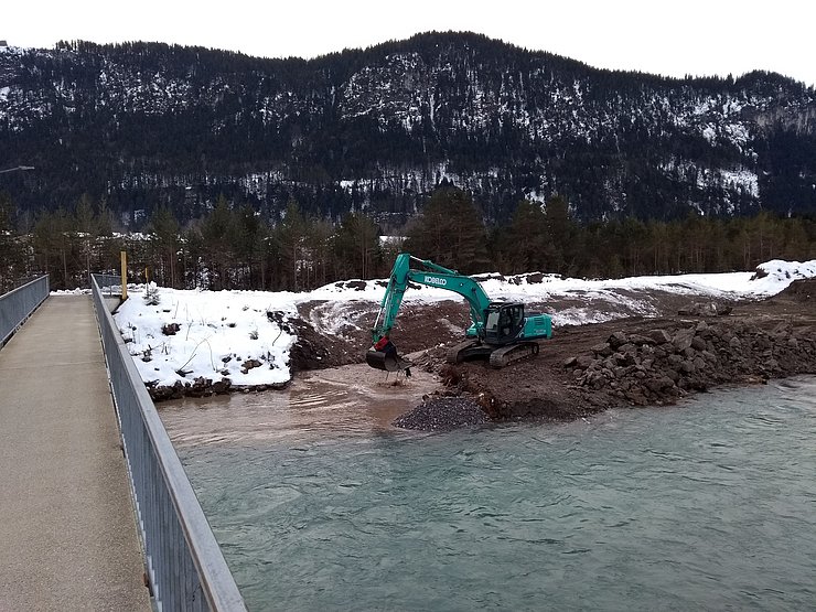 Erdarbeiten oberhalb der Fußgängerbrücke Höfen / Ehenbichl. Das neue Längsleitwerk wird in das Alte eingebunden.