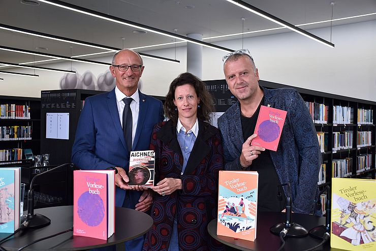 Gruppenfoto mit dem Landeshauptmann, Sonja Altenburger und Bernhard Aichner vor den Regalen der Innsbrucker Stadtbibliothek