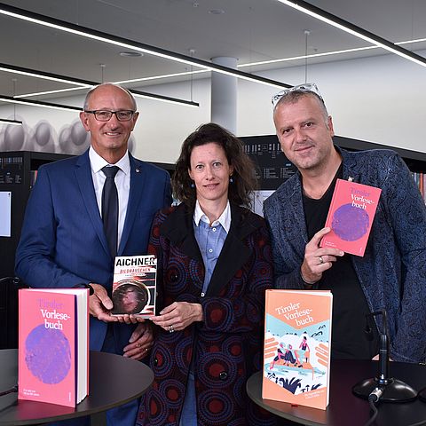 Gruppenfoto mit dem Landeshauptmann, Sonja Altenburger und Bernhard Aichner vor den Regalen der Innsbrucker Stadtbibliothek