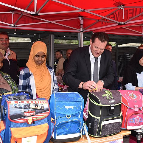 Zumtobel reinigt gemeinsam mit Flüchtlingen gebrauchte Schultaschen