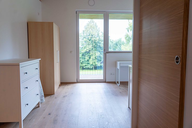 Blick in Zimmer mit Fenster und Holz-Möbeln