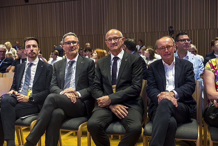 Vier Männer sitzend 