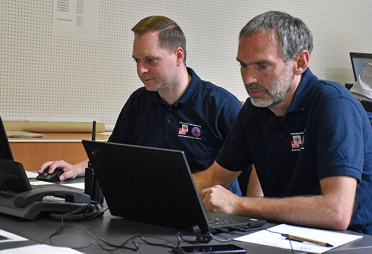 Zwei Mitglieder der Bezirkseinsatzleitung am Laptop im Rahmen der Übung.
