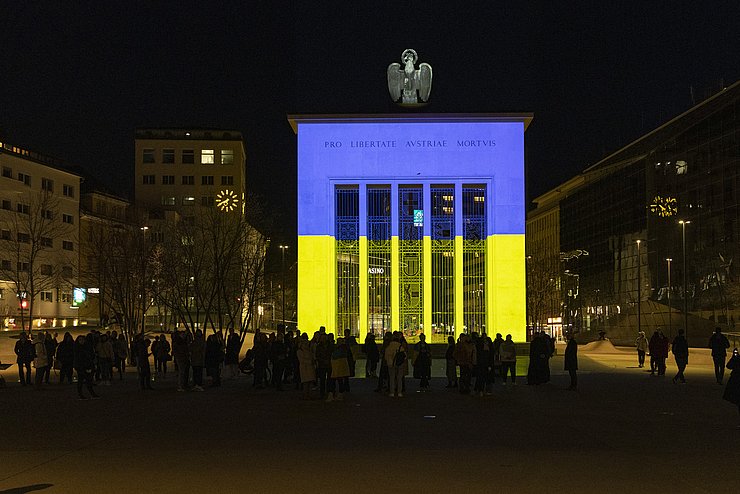 Denkmal am Landhausplatz leuchtet in blau-gelb, den Farben der ukrainischen Flagge.