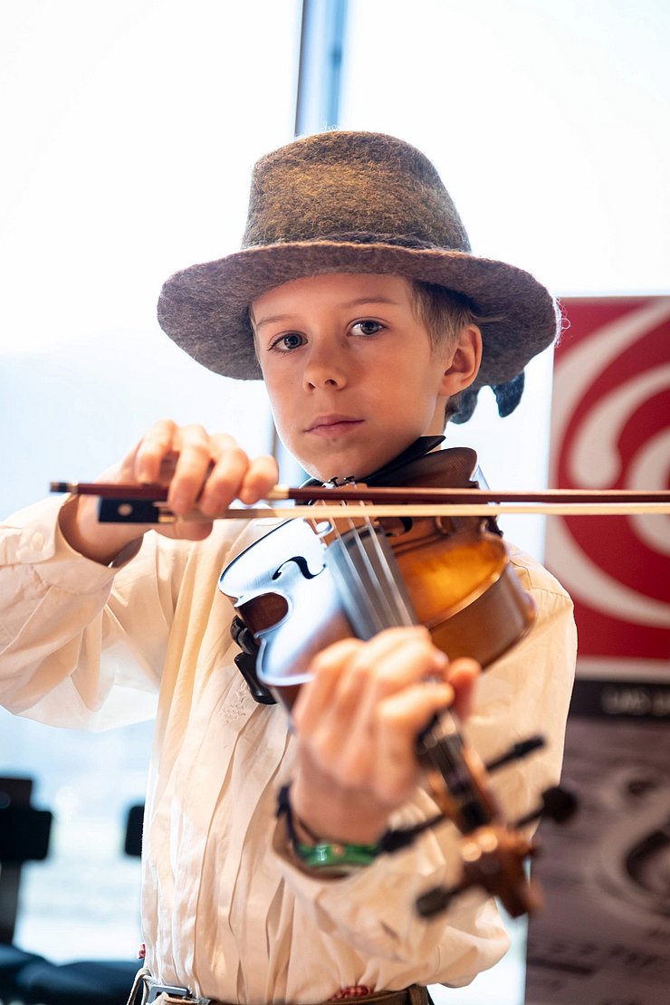 Ein junger Bub spielt Geige.