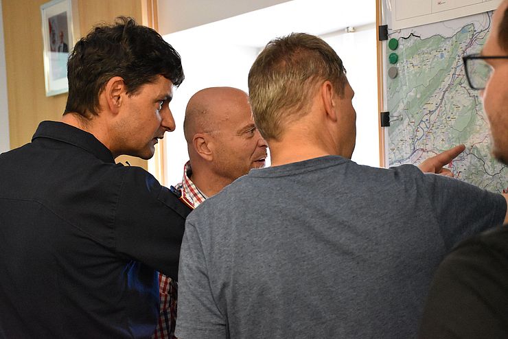 Drei Männer sehen sich eine Landkarte an.