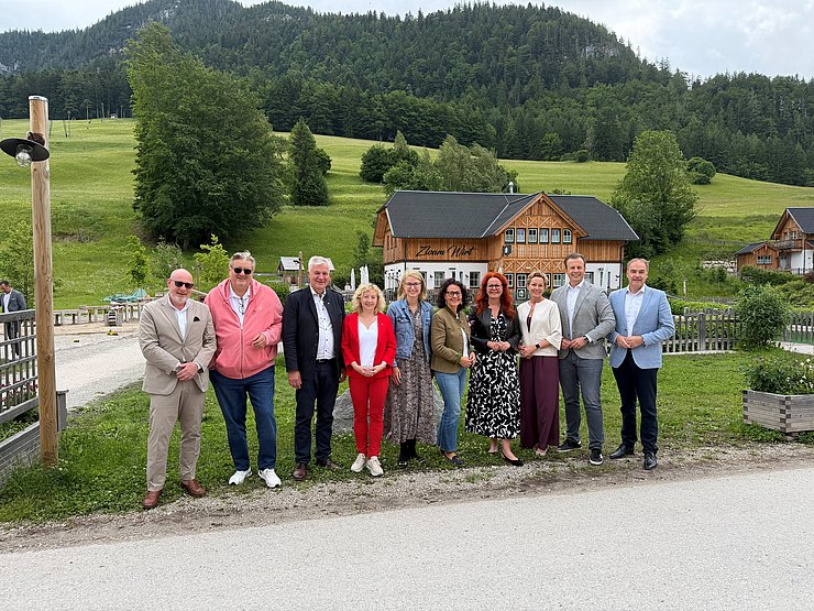 © Land Tirol Mehrere Personen stehen im Freien vor einem Hügel und blicken in die Kamera.