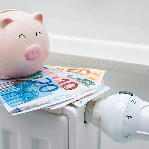 Heating,Thermostat,With,Piggy,Bank,And,Money,,Expensive,Heating,Costs