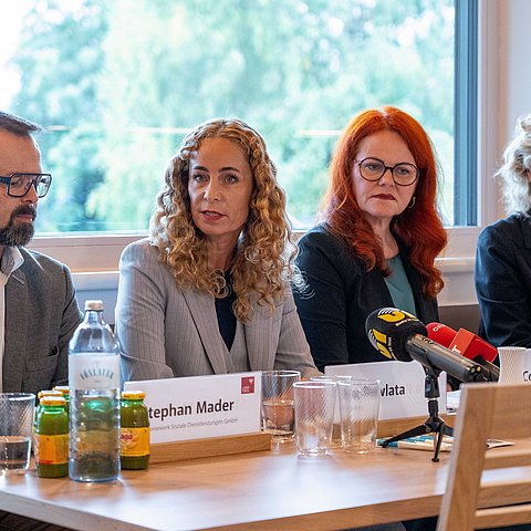 Personen sitzen nebeneinander