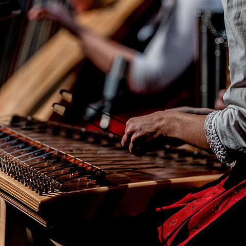 Nahaufnahme einer Frau, die Hackbrett spielt.