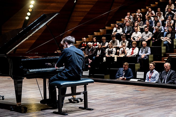 © Land Tirol/Kary Sophie Ein junger Mann spielt Klavier im Festspielhaus Erl.