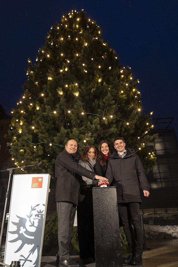 LHStv Josef Geisler, LRin Eva Pawlata, LVPin Sophia Kircher und der Fisser Bürgermeister Simon Schwendinger drücken auf einen roten Knopf und bringen den Baum zum Leuchten.
