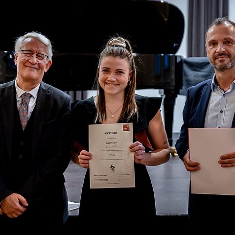Landesmusikdirektor Helmut Schmid (r.) und Johann Bair (Prof.-Dr.-Kurt-Ebert-Stiftung) gratulieren Anja Theiner zum Hauptpreis beim Kurt-Ebert-Klavierwettbewerb.