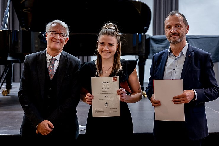 © Land Tirol/Sophie Kary Landesmusikdirektor Helmut Schmid (r.) und Johann Bair (Prof.-Dr.-Kurt-Ebert-Stiftung) gratulieren Anja Theiner zum Hauptpreis beim Kurt-Ebert-Klavierwettbewerb.