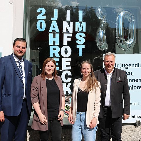 Gruppenfote mit den vier Personen vor Gebäude mit der Aufschrift "20 Jahre InfoEck Imst"