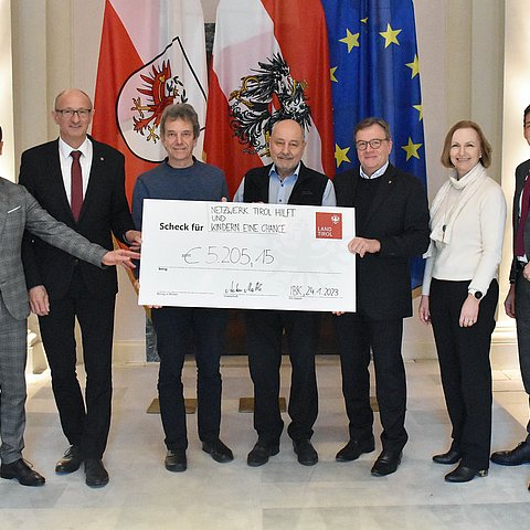 Gruppenfoto der genannten Personen mit einem großen Scheck in der Hand