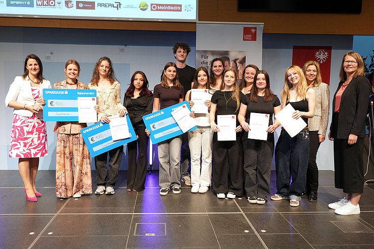 © Land Tirol/Trenker Jugendliche mit Urkunden und mehrere Erwachsene auf der Bühne