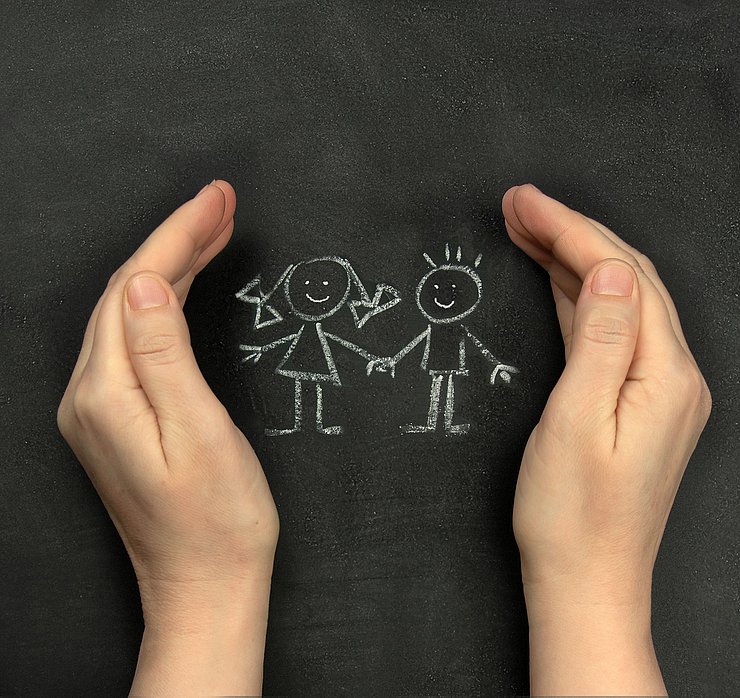 © shutterstock/1702487878 Hands,Protect,Children,Drawn,On,Blackboard,With,Chalk.,Concept,For