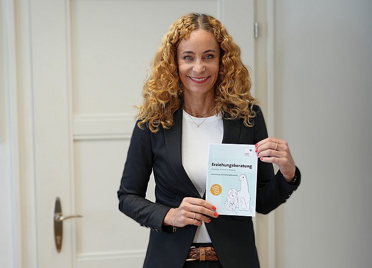 Landesrätin Eva Pawlata mit einem Flyer zur Erziehungsberatung in der Hand