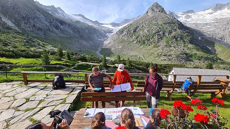 Gruppe sitzt in einer Hütte im Gebirge