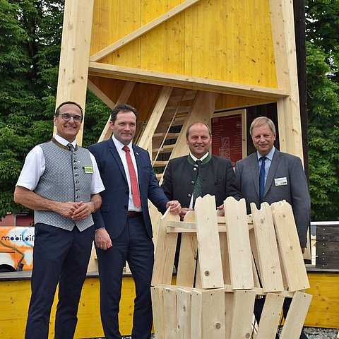 Vor einer für die Forsttagung aufgebauten, mehreren Meter hohen Holzkonstruktion stehen von links: Von links Kurt Ziegner, Vorstand Landesabteilung Forstplanung und Präsident Tiroler Forstverein, Landwirtschaftsminister Norbert Totschnig, LHStv Josef Geisler, Johannes Wohlmacher, Präsident Österreichischer Forstverein. 